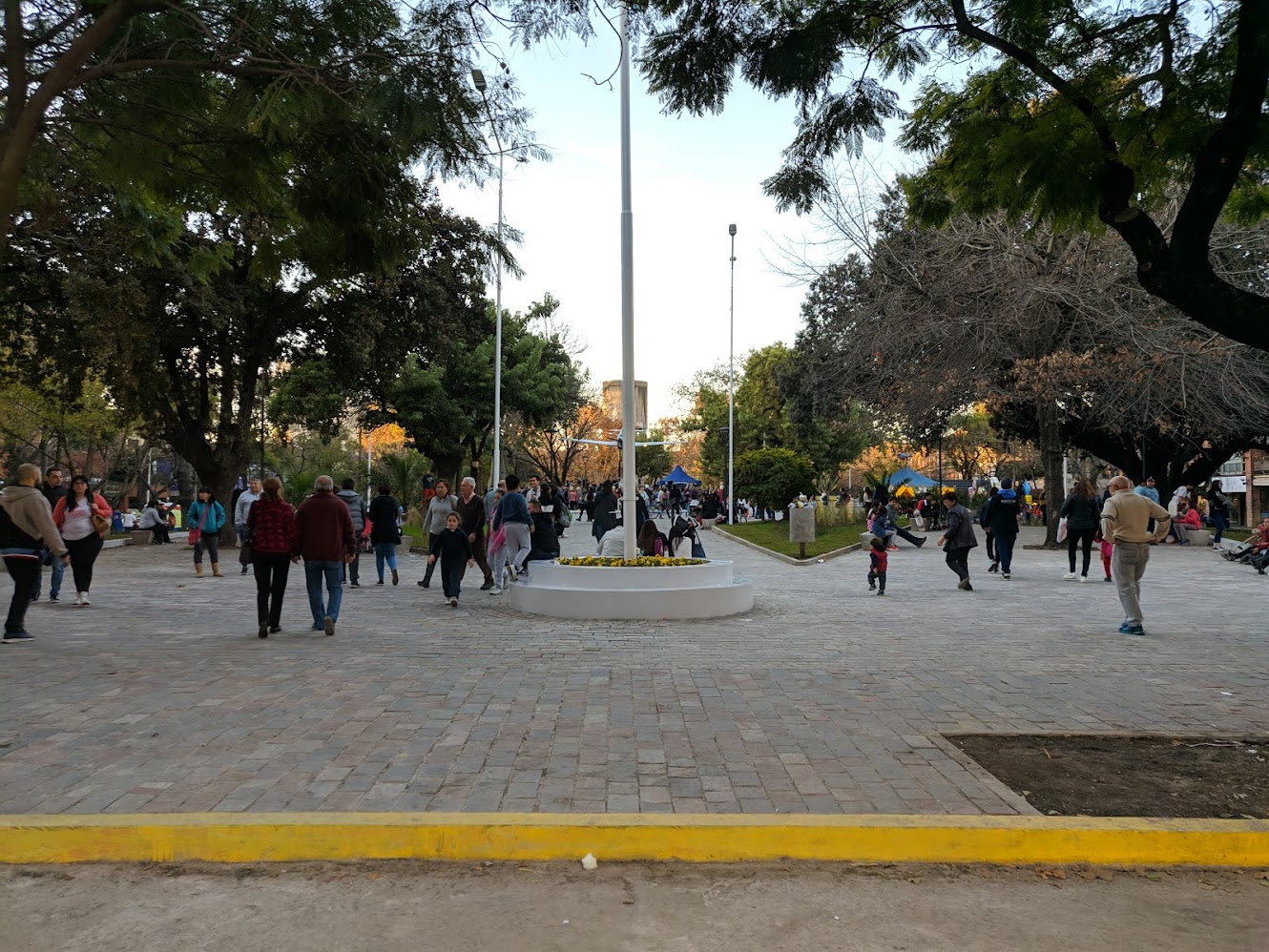 La plaza como espacio de encuentro: arbolado, paseo central y el avión como marca visual del barrio